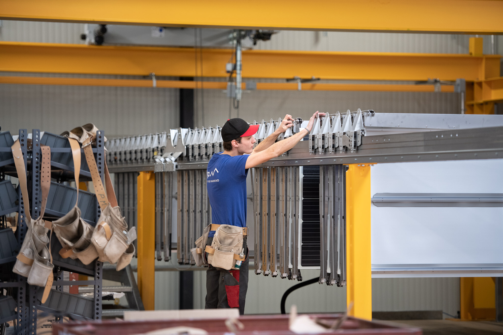 A workers handles a folding solar roof in a factory