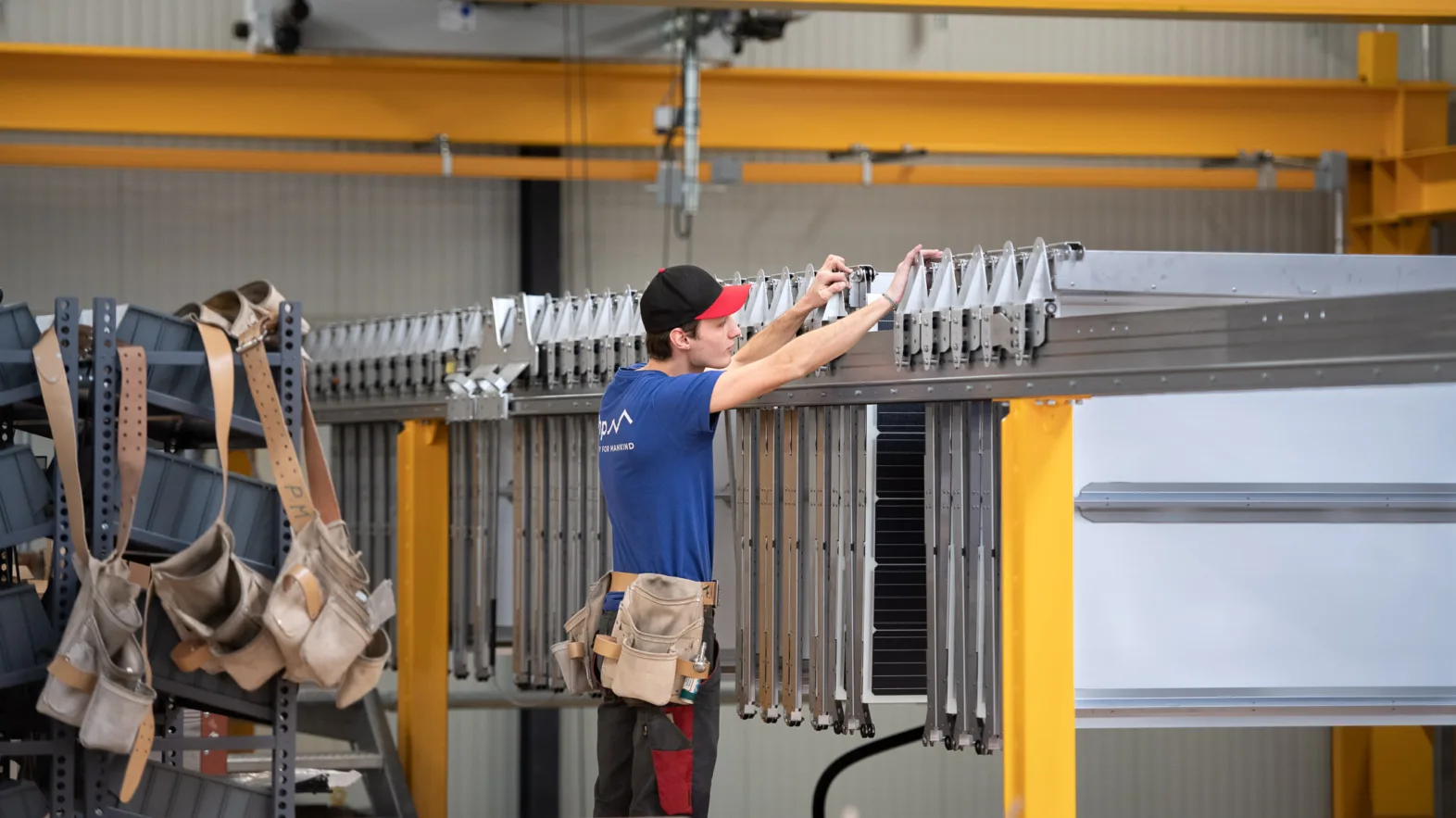 A workers handles a folding solar roof in a factory