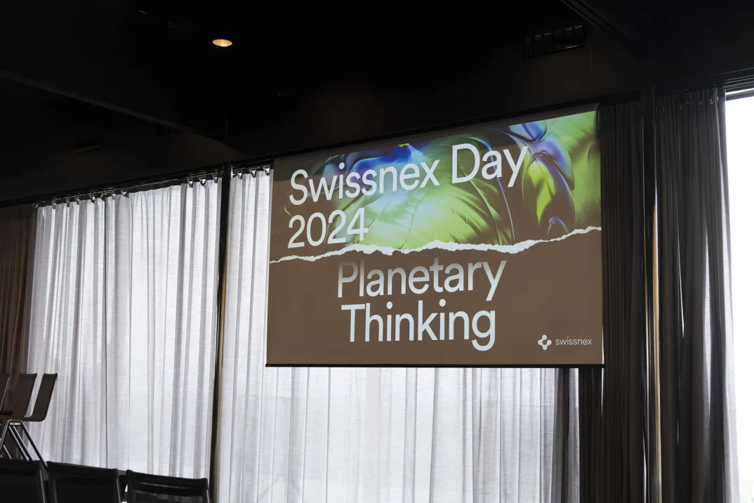 Un écran avec l'image promotionnelle de la "Swissnex Day 2024: Planetary Thinking" sur fond gris.