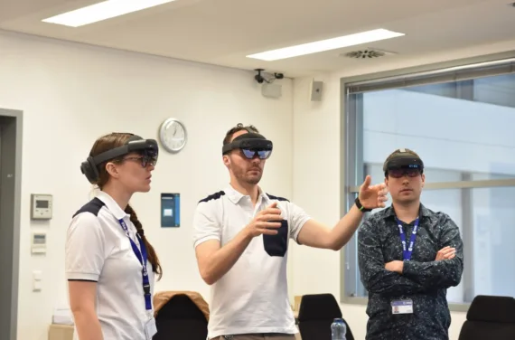 Marco Sieber, Rosemary Coogan und Raphaël Liegois betrachten eine virtuelle Darstellung der Blutgefäße im menschlichen Körper mit einer AR-Brille.