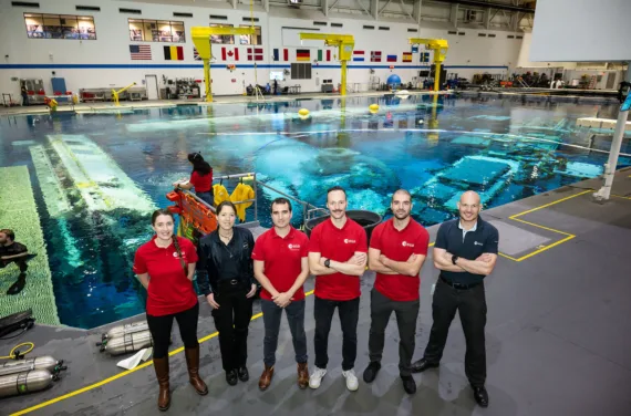 The new ESA astronauts and Alexander Gerst stand in front of NASA's Neutral Buoyancy Lab.