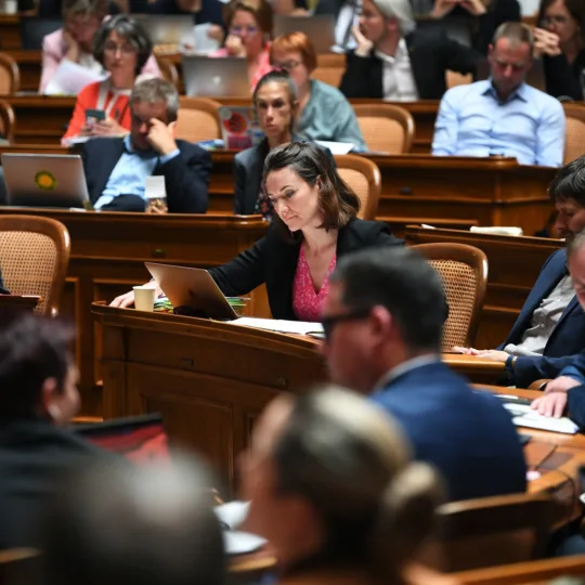 Parlamentarier sitzen in einem runden Plenarsaal.