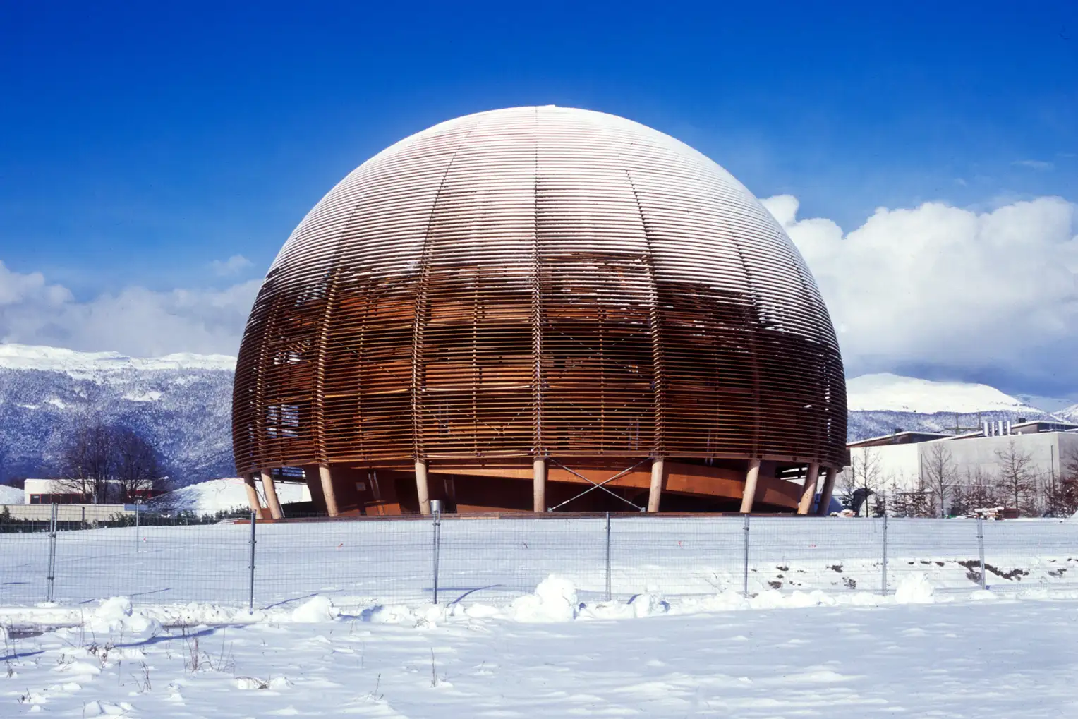 Le «Globe de la science» est recouvert de neige au milieu d'un champ enneigé sur fond de montagnes enneigées et de ciel bleu.