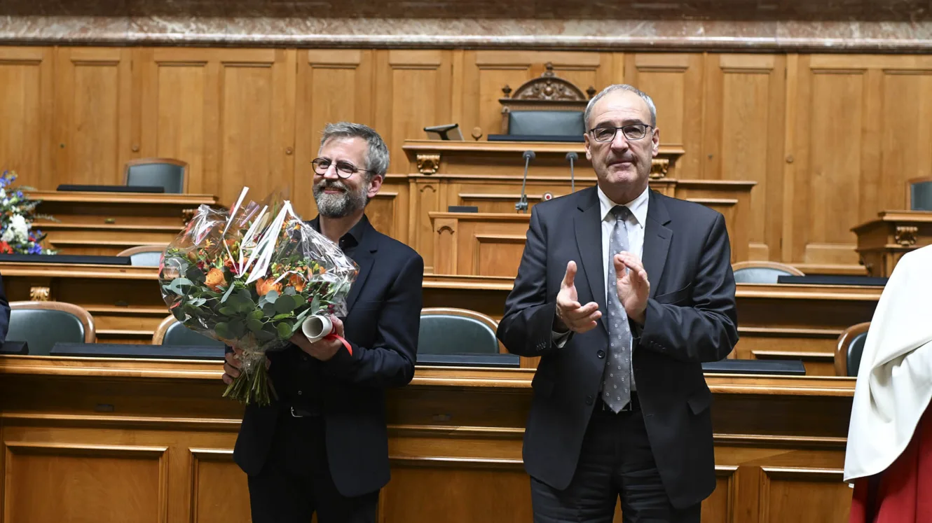 Photographie du psycholinguiste Pascal Gygax et du conseiller fédéral Guy Parmelin dans la salle du Conseil national