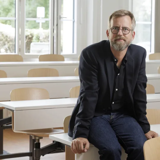 Fotoportait von Psycholinguist Pascal Gygax in einem Vorlesungssaal.