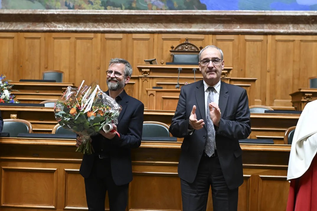 Photographie du psycholinguiste Pascal Gygax et du conseiller fédéral Guy Parmelin dans la salle du Conseil national