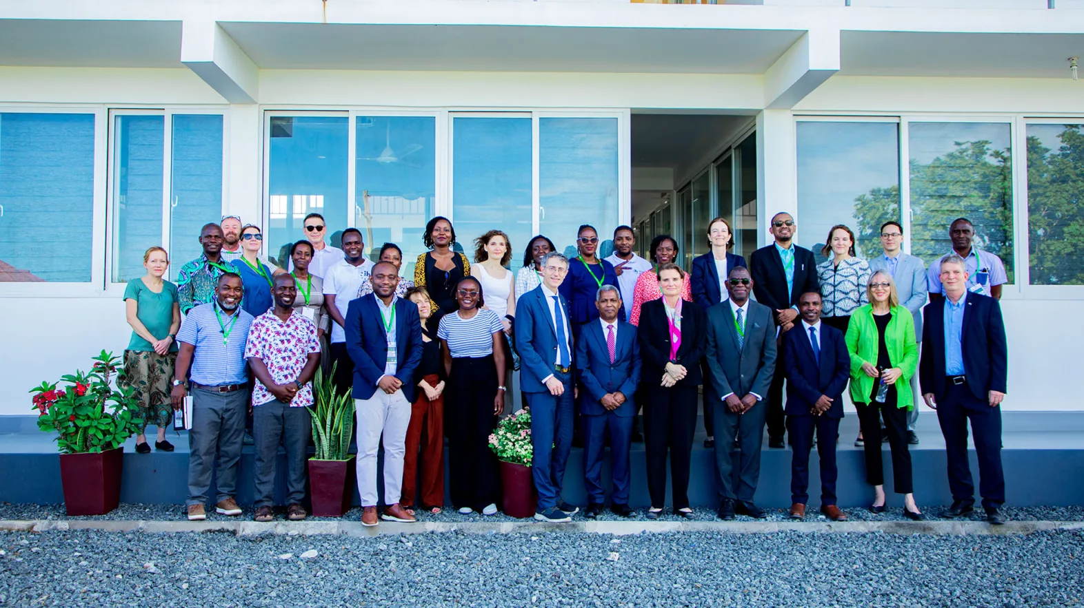 Group photo on a grey square in front of a white building.