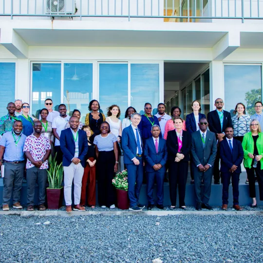 Group photo on a grey square in front of a white building.