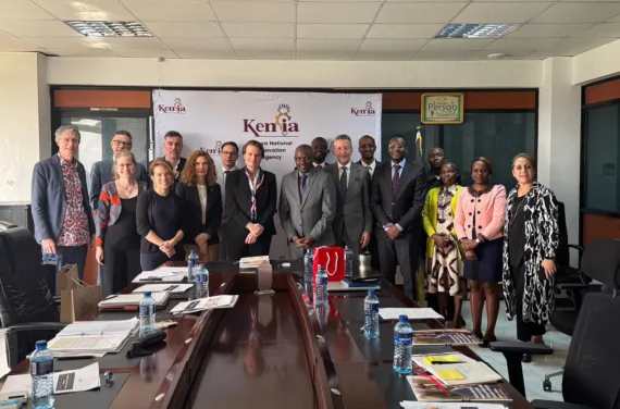 A group of people poses for a photo behind a long conference table.