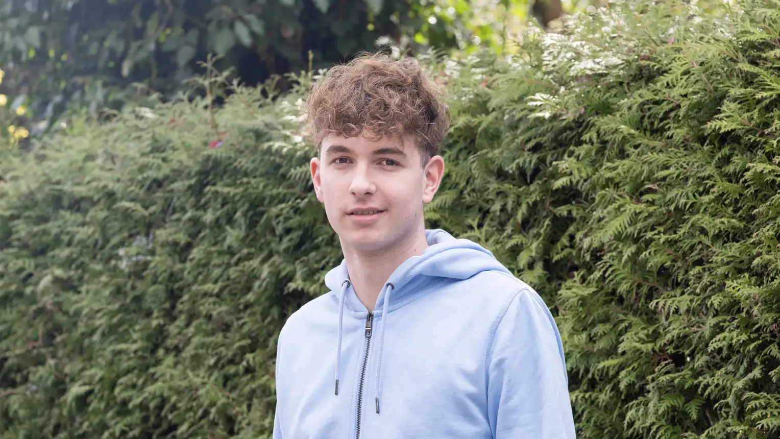 A young man in a light blue hoodie
