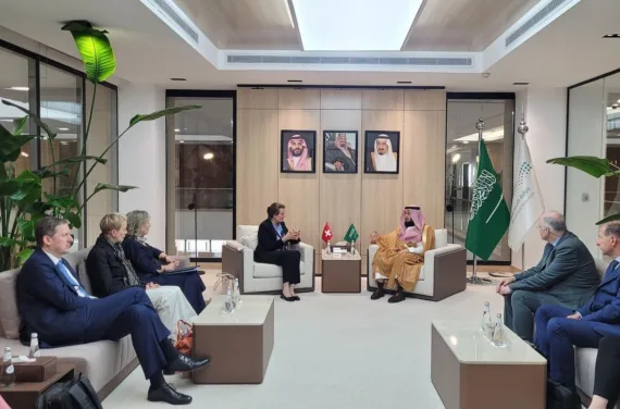 Bild 6 Minister Saudi Arabien Une femme et un homme sont assis sur deux fauteuils et discutent, entourés d'autres personnes.