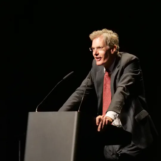 Michael Esfeld, Professor of Philosophy of Science at the University of Lausanne, stands behind a lectern and speaks into a microphone.