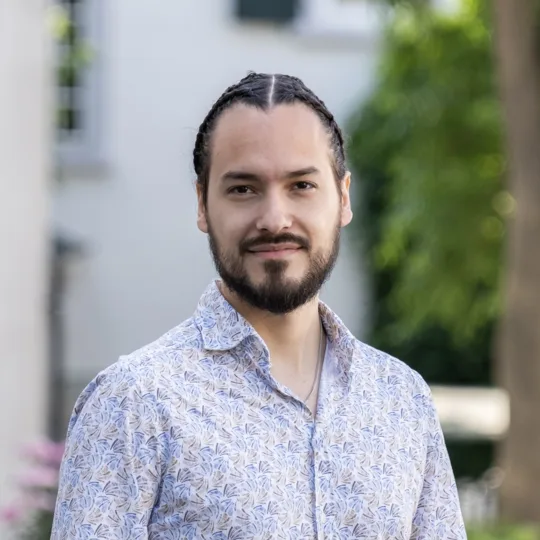 Portrait d'un jeune homme aux cheveux bruns foncés et vêtu d'une chemise.