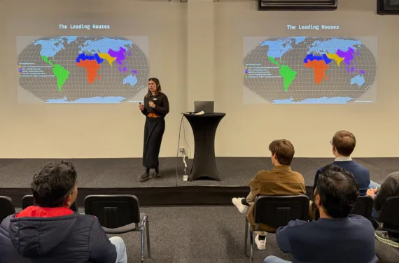 A person is standing in front of an audience, holding a presentation