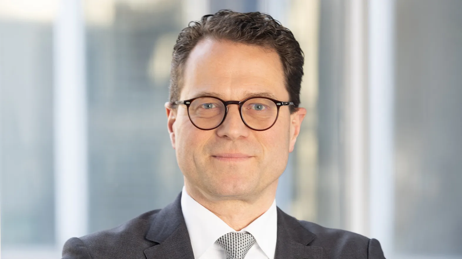Portrait of a man wearing a suit and glasses.