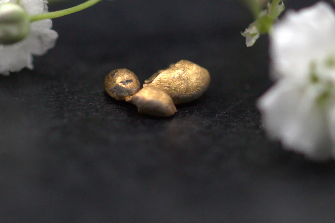 Trois morceaux d'or sur fond noir.