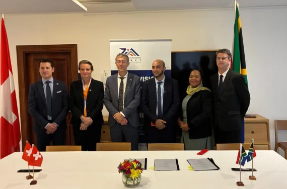 Signature Mo A 25 09 2025 Six personnes se tiennent derrière un pupitre entre les drapeaux suisse et sud-africain.