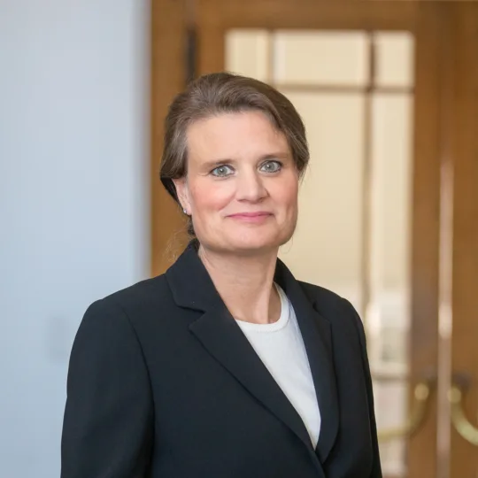 A woman in a blazer smiling at the camera.