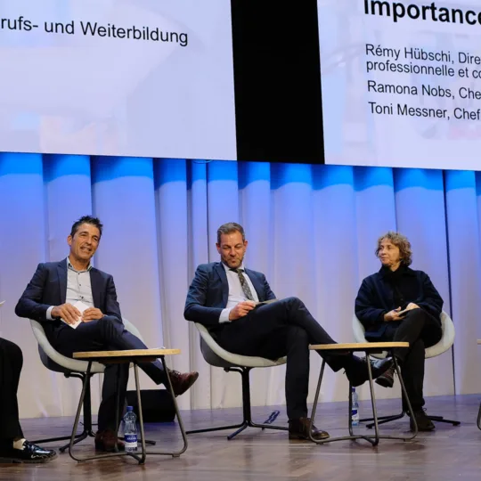 Cinq personnes de sexes, d'âges et d'origines différents discutent sur scène.