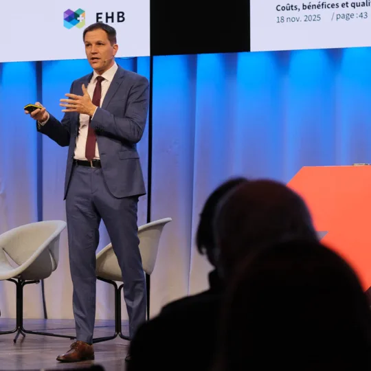 Un homme s'exprime sur scène lors d'un événement public.