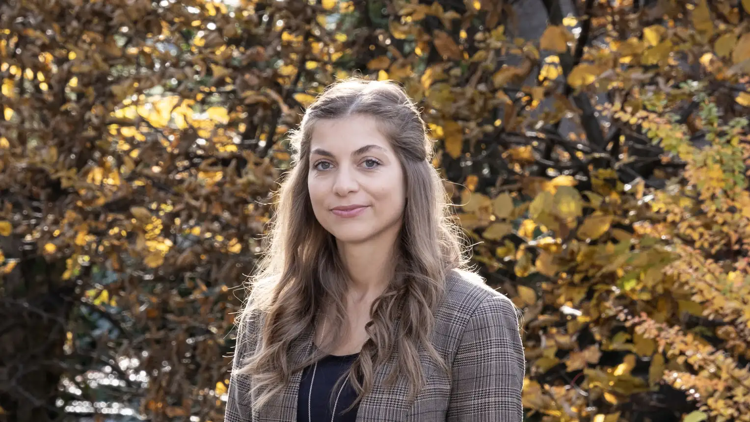 A woman with long brown hair smiles at the camera.