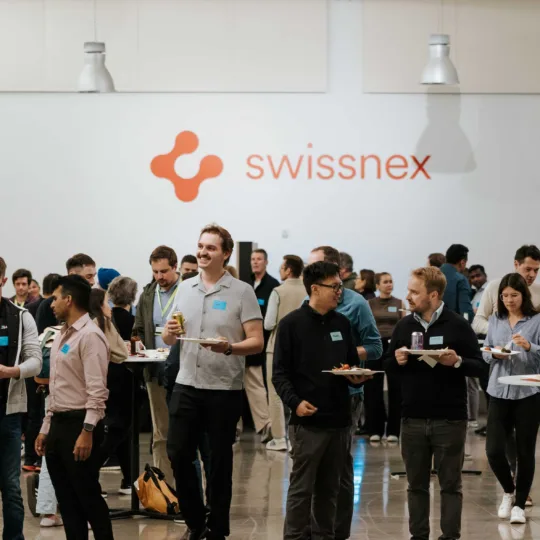 Eine Ansammlung von Menschen vor dem Swissnex-Logo.