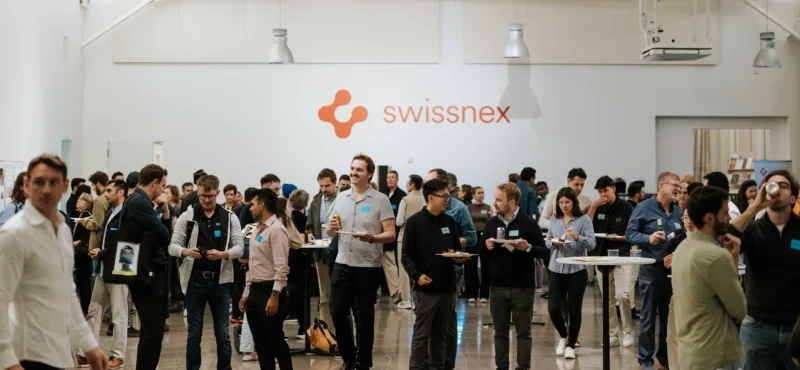 A crowd of people in front of the Swissnex logo.