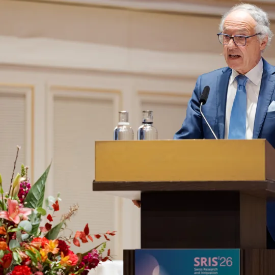 Ein Mann im Anzug hinter einem Rednerpult.