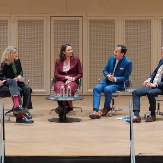 Fünf Personen diskutieren in einem Panel.