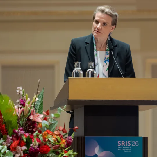 Eine Frau hält eine Rede an einem Rednerpult.