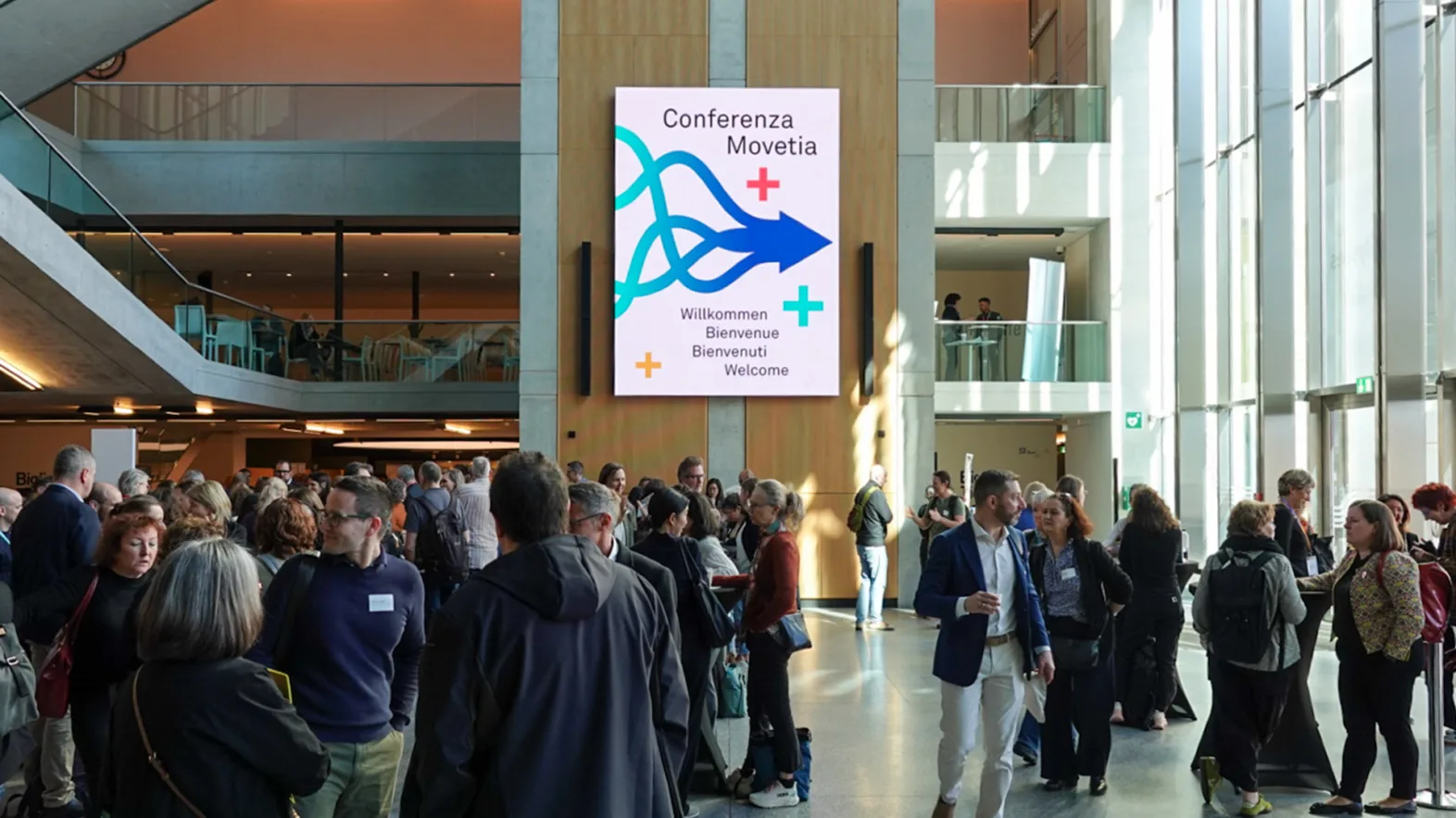 Eine Ansammlung von Menschen in einem grossen Eingangsbereich.