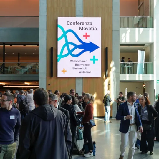 Eine Ansammlung von Menschen in einem grossen Eingangsbereich.