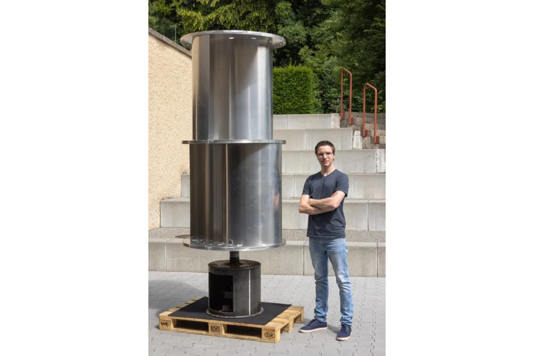 Ein junger Mann steht vor einer Turbine