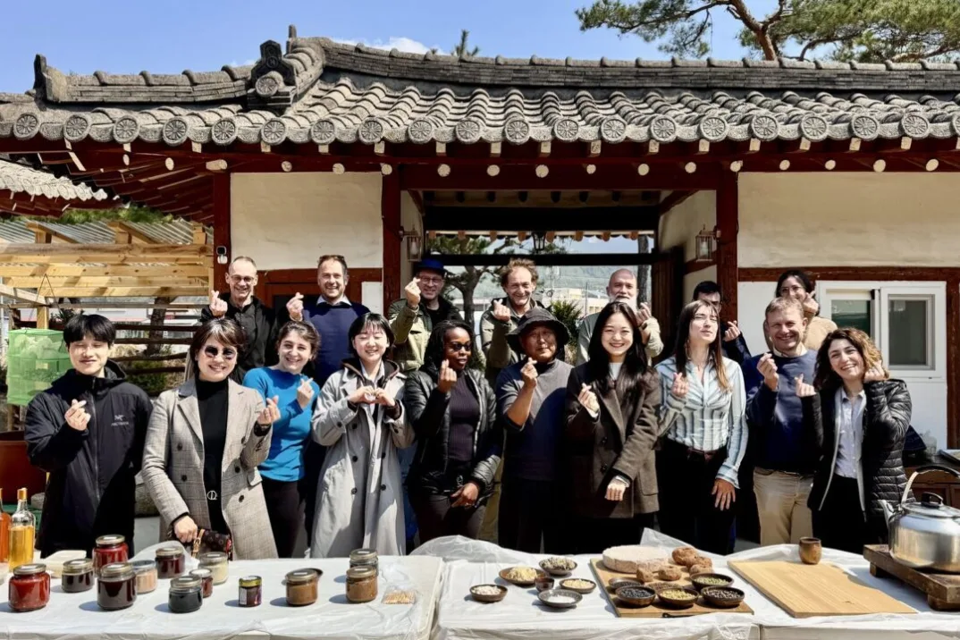A group photo taken in front of a table set with food.