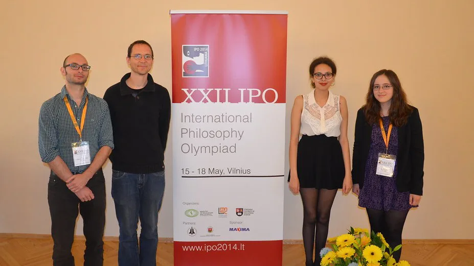 Gruppenbild von vier Personen neben einem Banner.